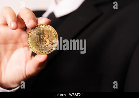 cryptocurrency Bitcoin. Women hold the cryptocurrency coin on hand. Physical bitcoins gold coin Stock Photo