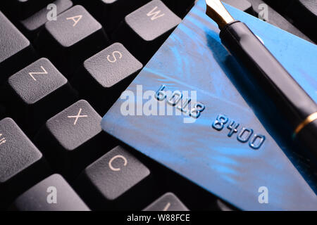 Credit card and fountain pen on a laptop. Selective focus, soft focus and shallow depth of fields - DOF Stock Photo