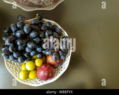 Healthy and fresh various fruit in a bowl on the table top view, grapes, apples, bananas healthy lifestyle Stock Photo