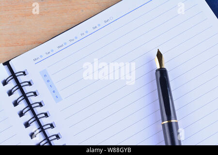 Notebook with fountain pen on wooden table Stock Photo