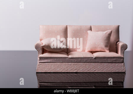 Pink small toy sofa isolated on a black and white background Stock Photo