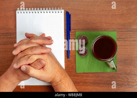On the table lie a pen, notebook, tea, sweets during negotiations Stock Photo