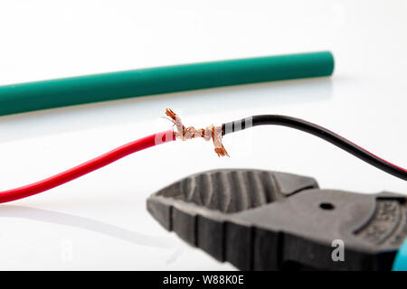 Twisting the two wires, side cutters are located side by side, all on a light background. Stock Photo
