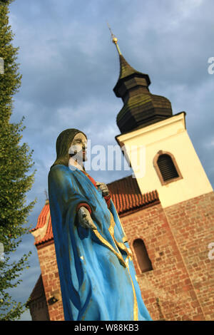 Antique statue of Jesus Christ on a greveyard, church in background Stock Photo