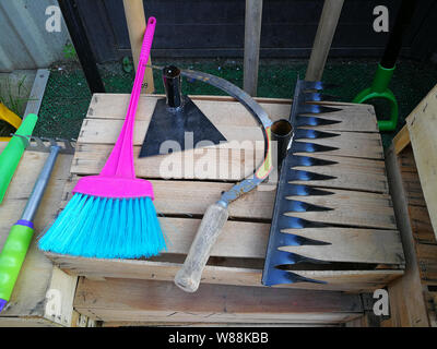 Garden tools lying on a wooden box in the garden Stock Photo