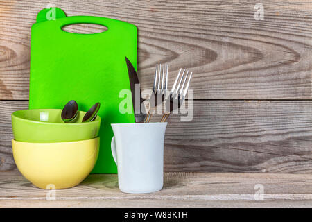 Plates, glass, forks, spoons after washing on wooden background. Stock Photo