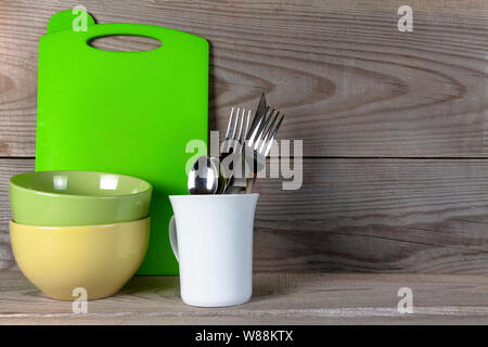 Plates, glass, forks, spoons after washing on wooden background. Stock Photo