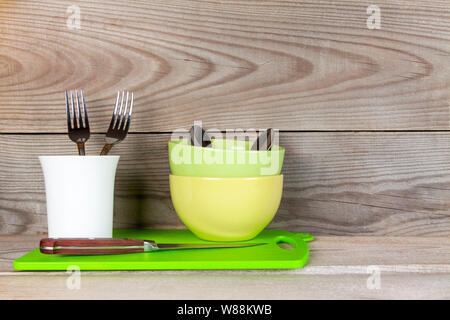 Plates, glass, forks, spoons after washing on wooden background. Stock Photo