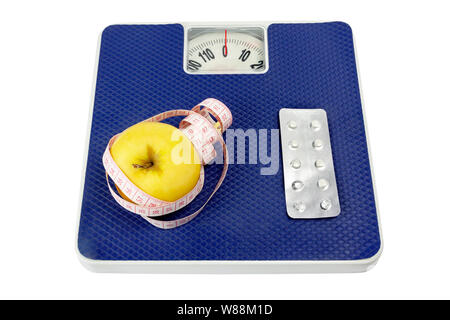 Healthy lifestyle concept. On the scales lie: on the one hand an apple and a measuring tape, on the other hand a medicine. Stock Photo