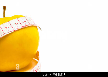 A yellow tape with a yellow apple on a white background. Isolate Stock Photo