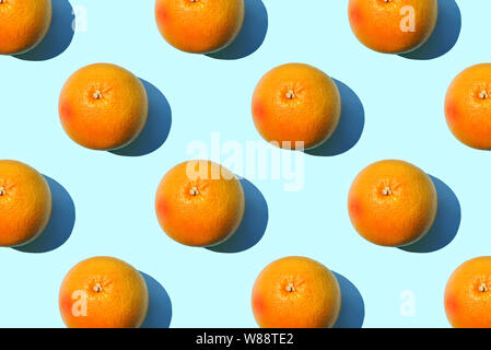 Ripe grapefruit pattern on blue background. Minimal flat lay concept. Stock Photo