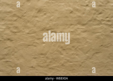 Rough bumpy brown yellow concrete plaster stucco texture or surface  background. Stock Photo