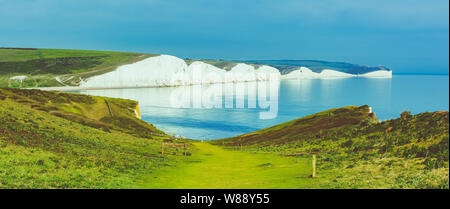 Hope Gap walk near Seaford, East Sussex, England. South Downs National park. View of blue sea, cliffs, beach, green fields, selective focus. Long phot Stock Photo