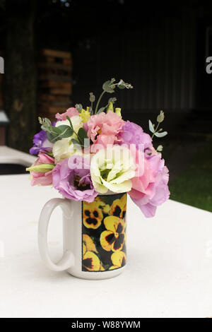 Multi Colored Lisianthus Flower Bouquet in a Cup with Pansies Stock Photo