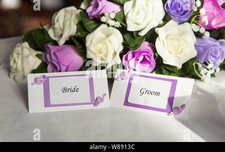 Bride & Groom Name Tags with White & Purple Flowers Stock Photo
