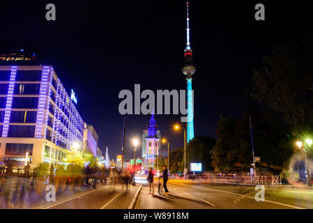 Night view of people and activity on Liebknecht Bridge during Festival of Lights, the projection mapping lighting art on Berliner Fernsehturm. Stock Photo