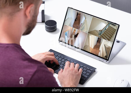 Close-up Of A Man Monitoring Black And White Video Footage On Laptop At Home Stock Photo