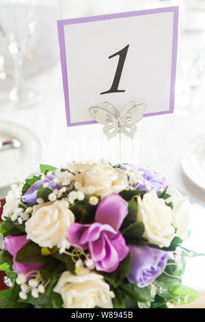 White & Purple Floral Table Decorations with Table Number 1 Stock Photo
