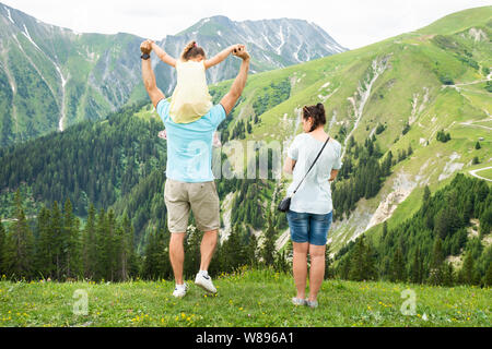 Rear View Of Family Looking At Panoramic Mountain View Stock Photo