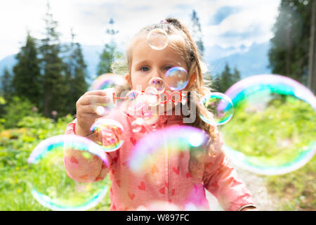 Girl Blowing Bubbles On A Sunny Day In Park Stock Photo