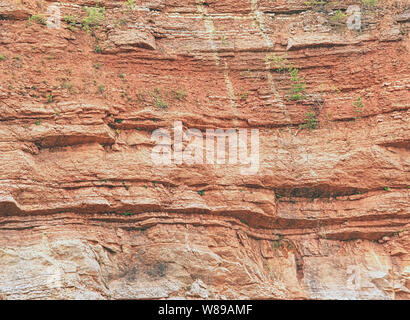 Ancient multi-layered lime and feric lines in wall surface of mine rocks Stock Photo