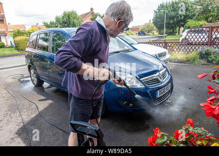 A man washing a car using a high pressure jet. Stock Photo