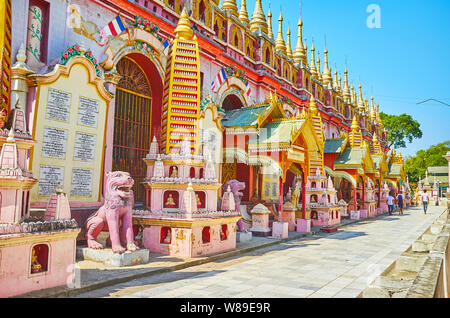 MONYWA, MYANMAR - FEBRUARY 22, 2018: The side wall of Thanboddhay Pagoda is decorated by relief patterns, inscriptions and lined with carved pagodas, Stock Photo