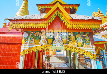 MONYWA, MYANMAR - FEBRUARY 22, 2018: The gate of the temple of Thanboddhay monastery is made of wood and decorated with fine carvings and paintings, o Stock Photo