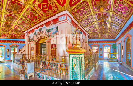 MONYWA, MYANMAR - FEBRUARY 22, 2018: Panorama of the prayer hall of Thanboddhay monastery's temple; it's decorated with carved wooden ceiling, reliefs Stock Photo