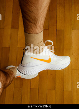 Increíble Monica Unión Paris France - Jul 13 2019: Man measuring new Nike Epic React Flyknit 2  running shoes equipment on the living room wooden floor manufactured by Nike  sportswear showing white logotype on side of the shoe Stock Photo - Alamy