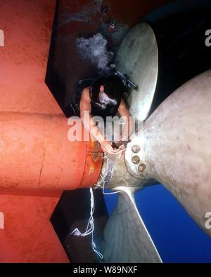 Navy Diver Petty Officer 2nd Class Benjamins use his dive knife to cut away heavy gauge fishing line to free the fouled propeller of the USS Grasp (ARS 51) in the Mediterranean Sea on June 15, 2000.  Benjamins, a Navy electricianХs mate, discovered the fishing line during a routine inspection of GraspХs hull and running gear.  The Grasp is a Safeguard class salvage ship home ported in Little Creek, Va. Stock Photo