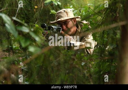 Marine Corps Lance Cpl. Ian M. Kearl aims an M240G medium machine gun in the dense tropical brush of the Kahuku Training Area on the island of Oahu, Hawaii, on July 15, 2004.  The training area is serving as a simulated terrorist training camp controlled by opposition forces participating in Rim of the Pacific Exercise 2004.  Rim of the Pacific is an international exercise that enhances the joint cooperation and proficiency of maritime and air forces of Australia, Canada, Chile, Peru, Japan, Republic of Korea, the United Kingdom and the United States. Stock Photo