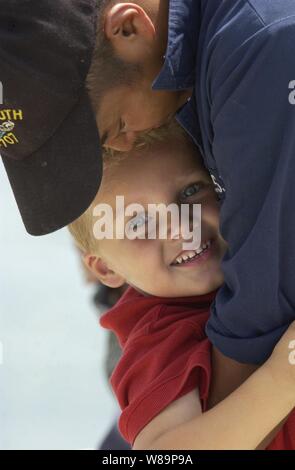 Navy Petty Officer 2nd class Tom Mitchell says goodbye to his son Christian before getting underway from Naval Base Point Loma, San Diego, Calif., on Aug. 12, 2004.  Mitchell is assigned to the USS Portsmouth (SSN 707), a Los Angeles Class Fast Attack nuclear-powered submarine.  Portsmouth will make a final cruise to Norfolk, Va., where it is scheduled for decommissioning in October of 2005. Stock Photo