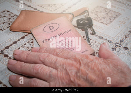 Senior hand with German driving license "Führerschein" and car key Stock Photo