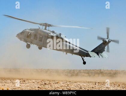 An MH-60S Knighthawk helicopter flares as it lands in a cloud of dust during a training mission near Naval Air Facility El Centro, Calif., on May 25, 2005.  The Knighthawk is attached to Helicopter Sea Combat Squadron 3, which trains all pilots and aircrew reporting to MH-60S squadrons worldwide. Stock Photo