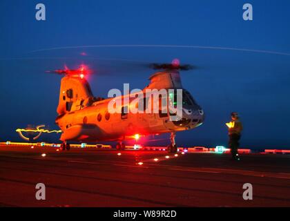 A U.S. Navy Landing Signal Enlisted prepares a CH-46 Sea Knight helicopter for lift-off from the flight deck of the USS Tarawa (LHA 1) while the ship operates at sea on July 29, 2005.  Tarawa is the flagship for Expeditionary Strike Group 1 and is on a Western Pacific deployment in support of Operation Iraqi Freedom. Stock Photo