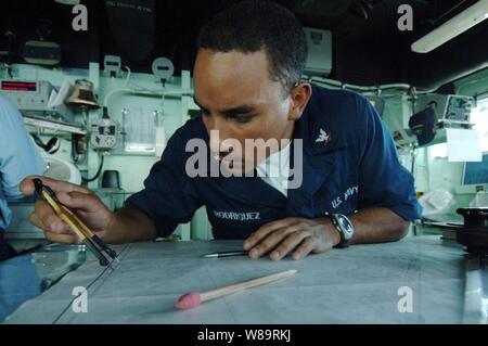 U.S. Navy Petty Officer 3rd Class Carlos Rodriguez plots his shipís position on a navigation chart on the bridge of the USS Carter Hall (LSD 50) during a underway replenishment with the Military Sealift Command oiler USNS Rappahannock (T-AO 204) in the Persian Gulf on Feb. 16, 2006.  Carter Hall is conducting maritime security operations in the Gulf region as part of the USS Nassau (LHA 4) Expeditionary Strike Group.  Rodriguez is a Navy quartermaster on board the Carter Hall. Stock Photo