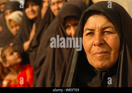 Iraqi women line up to receive humanitarian assistance boxes from U.S. Army soldiers in Kamaliya, Iraq, on April 28, 2006.  Soldiers from Delta Company, 3rd Battalion, 67th Armored Regiment, 4th Brigade, 101st Airborne Division, are passing out donated supplies to the villagers. Stock Photo