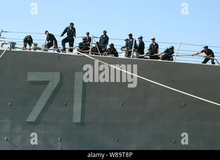 U.S. Navy sailors aboard the guided missile destroyer USS Ross (DDG 71) heave around on the mooring lines as the ship ties up to the pier in Souda Bay in Crete, Greece, on June 25, 2006.  Ross is in Souda Bay for a port visit during its deployment. Stock Photo