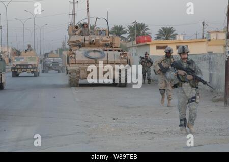 U.S. Army Soldiers of 1st Battalion, 67th Armored Regiment, provide security for Iraqi army soldiers from the 8th Iraqi Army Division during house searches in Diwaniwah, Iraq, on Sept. 16, 2006. Stock Photo