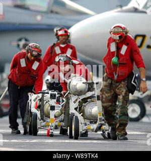 U.S. Navy Airman Miguel Torres, Petty Officers 2nd Class Damon Thomas, Mike Catron and Petty Officer 3rd Class Jason Arroyo move carts loaded with GBU-12 Paveway II laser-guided and GBU-38 global-positioning-system guided bombs to an F/A-18F Super Hornet aircraft on the flight deck of the aircraft carrier USS Dwight D. Eisenhower (CVN 69) on Nov. 22, 2006.  Eisenhower is deployed in support of maritime security operations in the Arabian Sea.  The Navy aviation ordnancemen are attached to Strike Fighter Squadron 103. Stock Photo