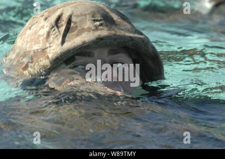 A U.S. Marine from Golf Company, 2nd Battalion, 1st Marine Regiment, swims across a training tank pool during annual swim qualifications at Camp Pendleton, Calif., on Nov. 29, 2006.  The swim qualification is designed for Marines to maintain amphibious operation readiness. Stock Photo