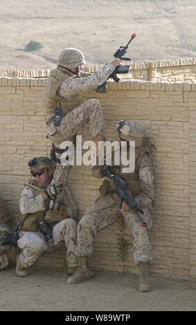 U.S. Navy Petty Officer 2nd Class Scott Taylor (left) and an unidentified Marine help another Marine scale a wall during a training exercise at Marine Corps Base Camp Pendleton, Calif., on Aug 12, 2008.  The training is designed to simulate urban combat situations that the Marines will face in future deployments.  The Marines are assigned to Echo Company, 2nd Battalion, 1st Marine Division. Stock Photo