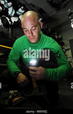 U.S. Navy Petty Officer 2nd Class Jason Bruce checks the emergency signal strobe light on a survival vest for Helicopter Sea Combat Squadron 8 in the paraloft aboard the aircraft carrier USS John C. Stennis (CVN 74) underway in the Pacific Ocean on May 5, 2009.  The ship and embarked Carrier Air Wing 9 are on a six-month deployment in the western Pacific Ocean. Stock Photo