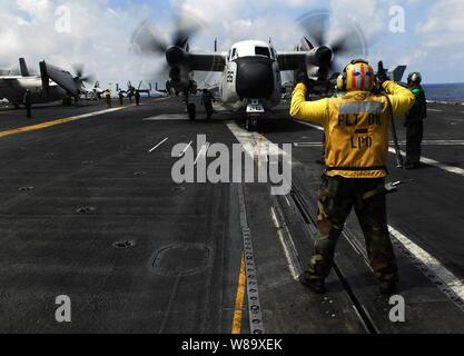 U.S. Navy Petty Officer 1st Class James Webb directs a C-2A Greyhound aircraft from Fleet Logistics Support Squadron 30 before launching from the flight deck of the aircraft carrier USS John C. Stennis (CVN 74) in the Pacific Ocean on May 6, 2009.  The Stennis and Carrier Air Wing 9 are on a six-month deployment to the western Pacific. Stock Photo