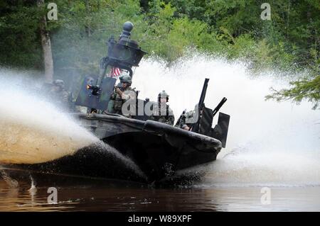U.S. Navy special warfare combatant-craft crewmen (SWCC) bring a boat ...