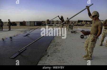 U.S. Navy Seabees with Naval Mobile Construction Battalion 40 lay concrete for a project at Camp Deh Dadi II in northern Afghanistan on Sept. 25, 2010. Stock Photo