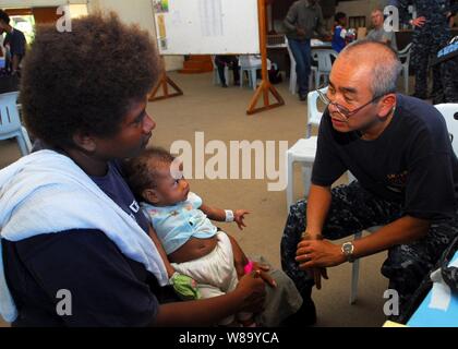 U.S. Navy Cmdr. Mark Nguyen (right) embarked aboard the Royal Australian Navy landing ship heavy HMAS Tobruk (L 50), consults with a patient during a medical civic action program at Malaguna Technical High School in Rabaul, Papua New Guinea, on Sept. 4, 2010.  Nguyen was part of a contingent of 64 sailors and nongovernmental organization members assigned to the Military Sealift Command hospital ship USNS Mercy (T-AH 19) that was embarked aboard Tobruk to conduct the final portion of Pacific Partnership 2010, a humanitarian and civic assistance operation designed to strengthen regional partners Stock Photo