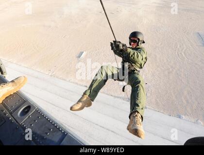 U.S. Navy Petty Officer 2nd Class Michael Reedy, assigned to Mobile Diving and Salvage Unit 2 rappels from an SH-60 Seahawk helicopter during a joint training event between U.S. and U.K. sailors in Manama, Bahrain, on Oct. 20, 2010.  Mobile Diving and Salvage Unit 2 supports maritime security operations in the U.S. 5th Fleet area of responsibility. Stock Photo