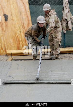 Petty Officer Selina Rodriguez, assigned to Naval Mobile Construction Battalion 7, uses a bull float to finish concrete at Kandahar Airfield on Feb. 17, 2012.  Naval Mobile Construction Battalion 7 and its detachments are one of two Seabee battalions supporting the International Security Assistance Force as part of Task Force Stethem, operating in the U.S. Central Command area of responsibility. Stock Photo